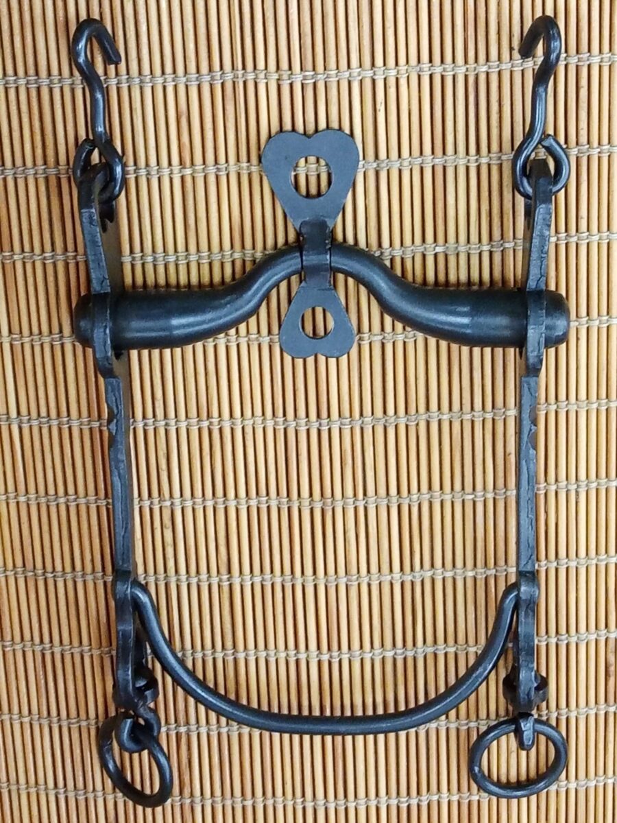 Bocado vaquero, barra curva, embocadura palometa, pavonado.